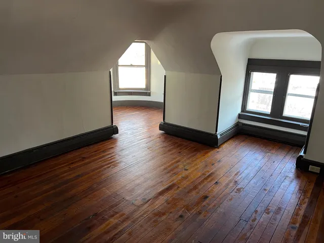 a view of a room with wooden floor and a window