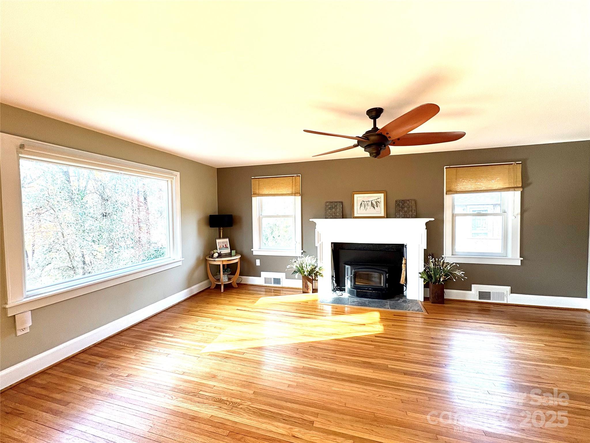 114 Broadway Tryon, NC 28782 - Photo 11 of 41 an empty room with fireplace wooden floor and windows
