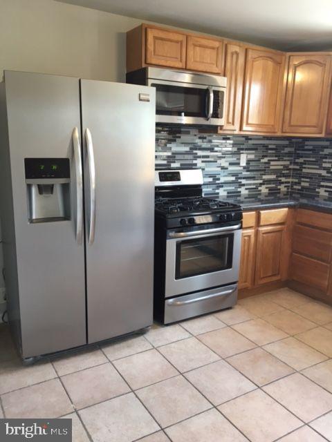 2445 East Huntingdon Street Philadelphia, PA 19125 - Photo 17 of 24 a kitchen with granite countertop a refrigerator and a sink