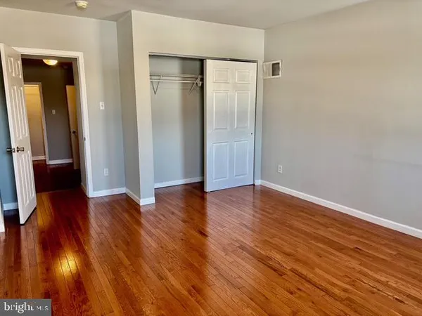 an empty room with wooden floor and closet