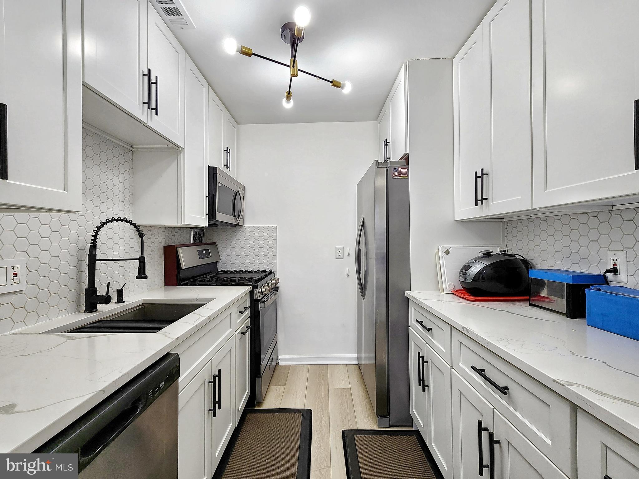 2901 Charing Cross Road, Unit 8 Falls Church, VA 22042 - Photo 13 of 40 a kitchen with stainless steel appliances granite countertop a sink stove refrigerator and cabinets