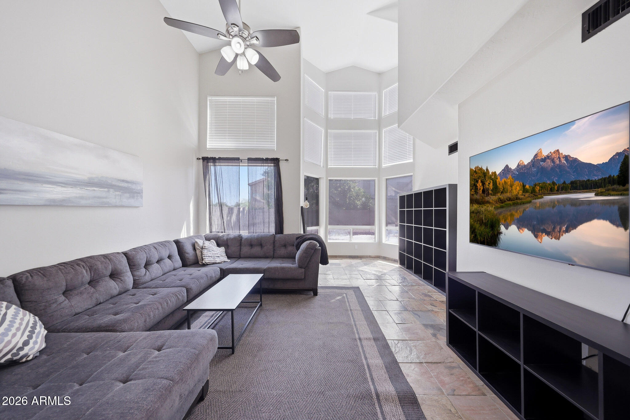 2167 East Nighthawk Way Phoenix, AZ 85048 - Photo 2 of 28 a living room with furniture a chandelier and a flat screen tv