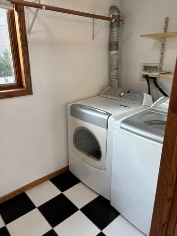 a room with a black white checkered floor and a large mirror on a dresser