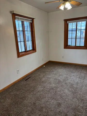 an empty room with a bathroom and a window