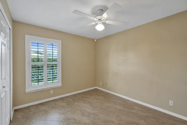 an empty room with a ceiling fan and a window