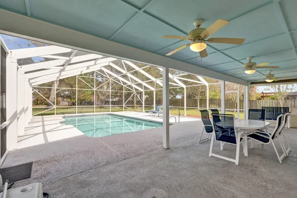 a view of a patio with table and chairs and floor to ceiling window