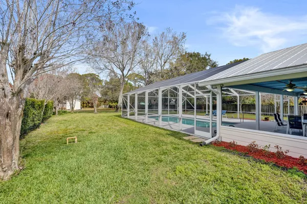 a backyard of a house with large trees and wooden fence
