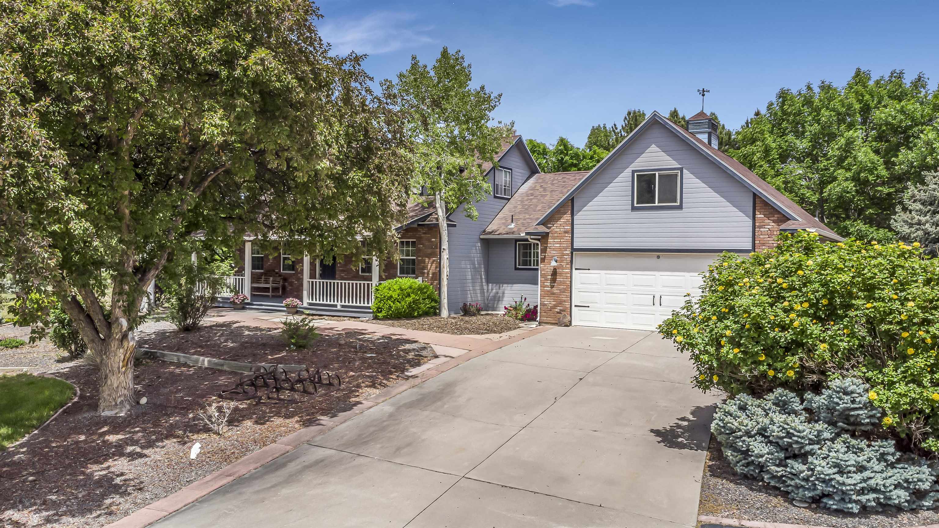 a front view of a house with a yard and trees