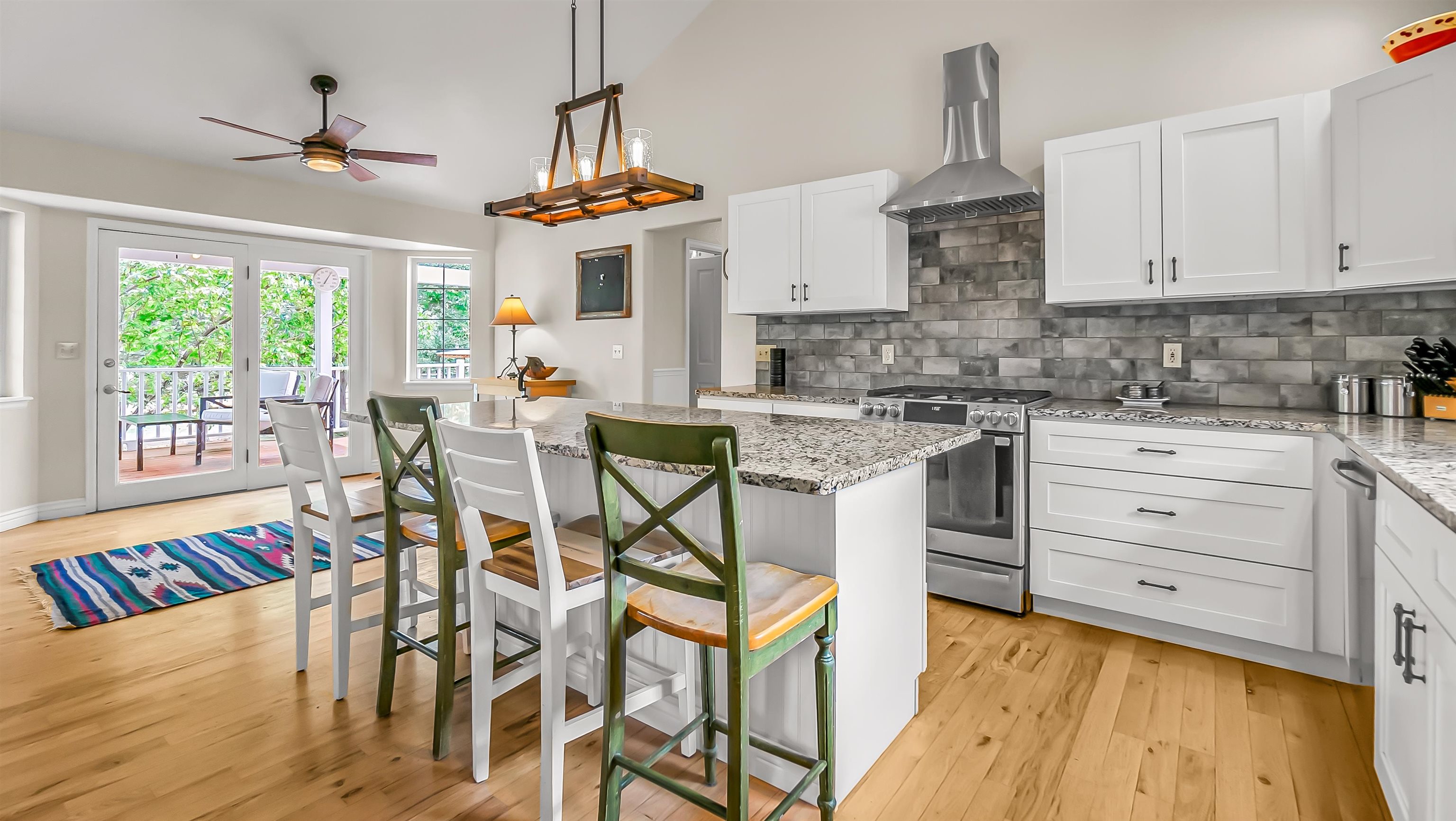2346 Sundial Road Grand Junction, CO 81505 - Photo 12 of 41 a kitchen with stainless steel appliances kitchen island granite countertop a table chairs in it and wooden floors