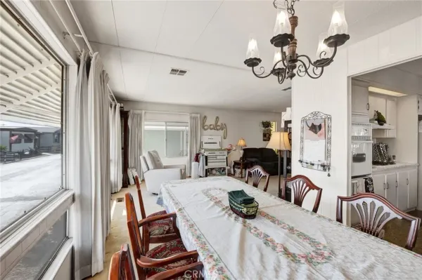 a view of a dining room with furniture a chandelier and wooden floor