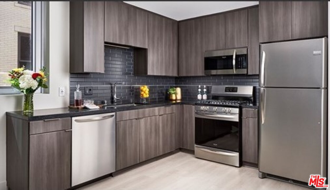 732 South Spring Street, Unit 918 Los Angeles, CA 90014 - Photo 4 of 31 a kitchen with stainless steel appliances granite countertop a refrigerator stove a sink dishwasher and microwave oven