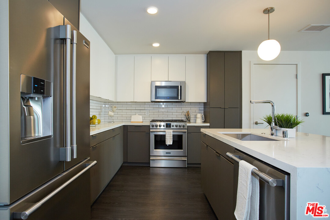 732 South Spring Street, Unit 918 Los Angeles, CA 90014 - Photo 9 of 31 a kitchen with stainless steel appliances granite countertop a refrigerator a stove and a sink