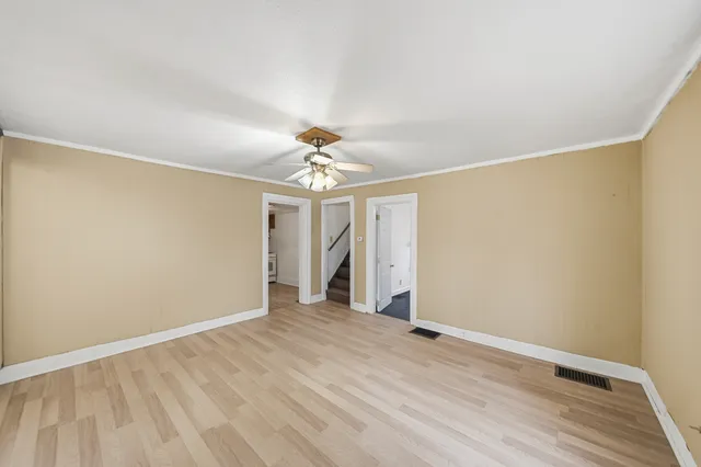 a view of an empty room with wooden floor