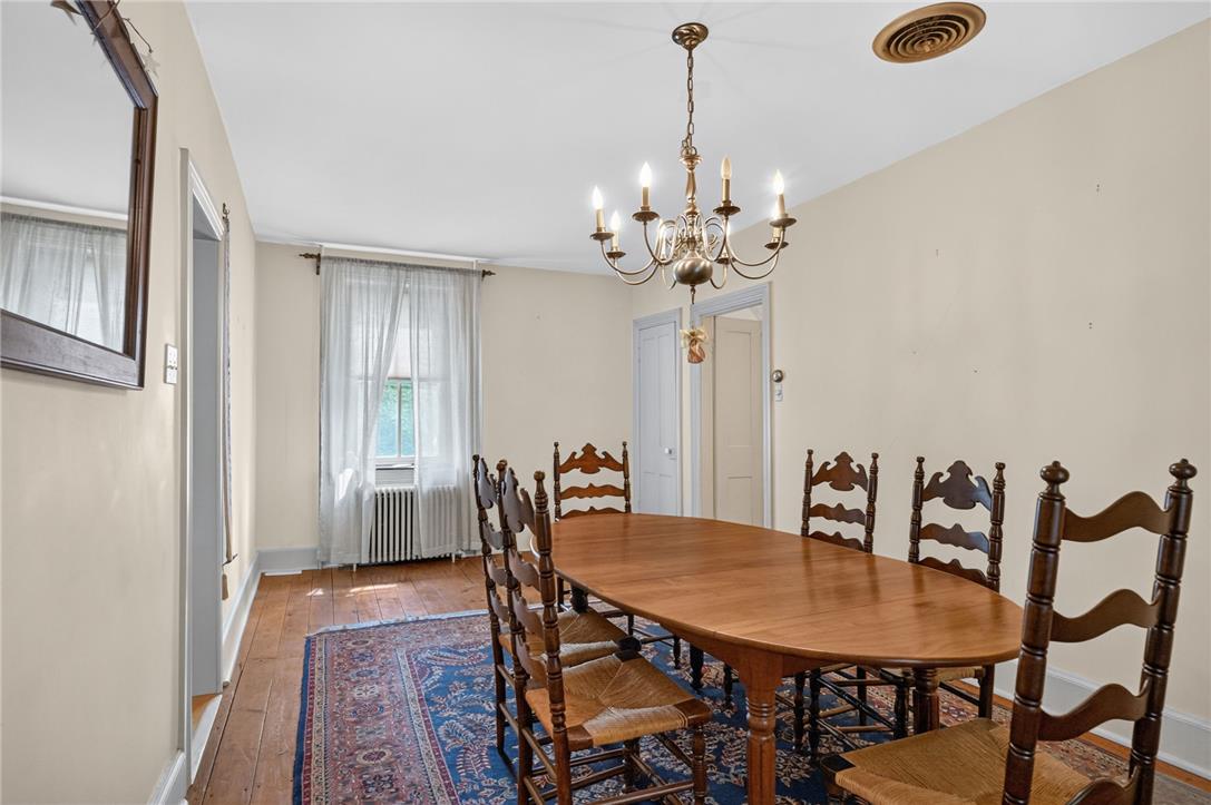 765 East Macada Road Bethlehem, PA 18017 - Photo 14 of 46 A classic dining area with hardwood floors, a vintage chandelier, and a bright window.