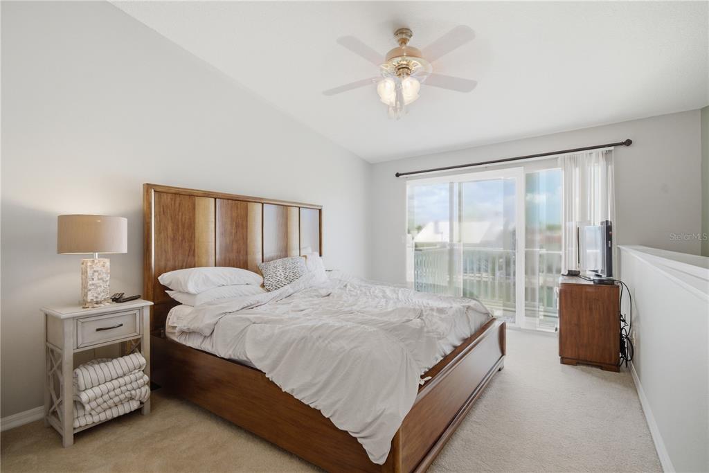 643 Garland Circle Indian Rocks Beach, FL 33785 - Photo 34 of 81 a bedroom with a bed chandelier and a window