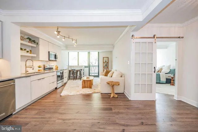 a large white kitchen with window and stainless steel appliances