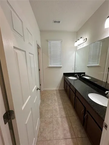 a bathroom with a double vanity sink a toilet and a mirror