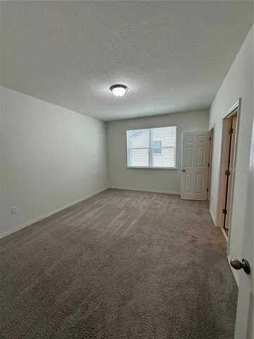 an empty room with a window and a refrigerator