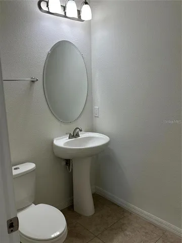 a bathroom with a sink toilet and a mirror