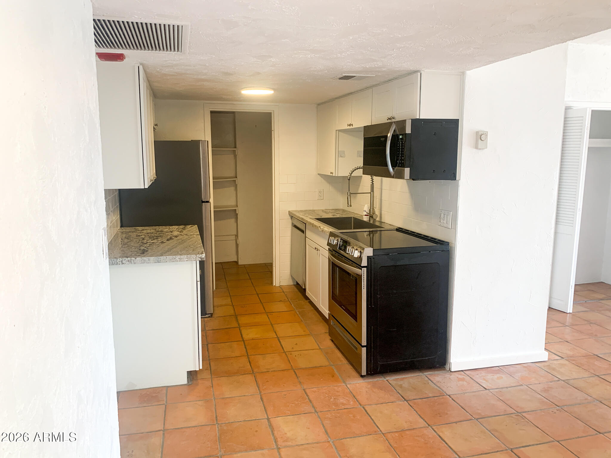 805 North 4th Avenue, Unit 902 Phoenix, AZ 85003 - Photo 4 of 35 a kitchen with stainless steel appliances granite countertop a stove a refrigerator and a microwave