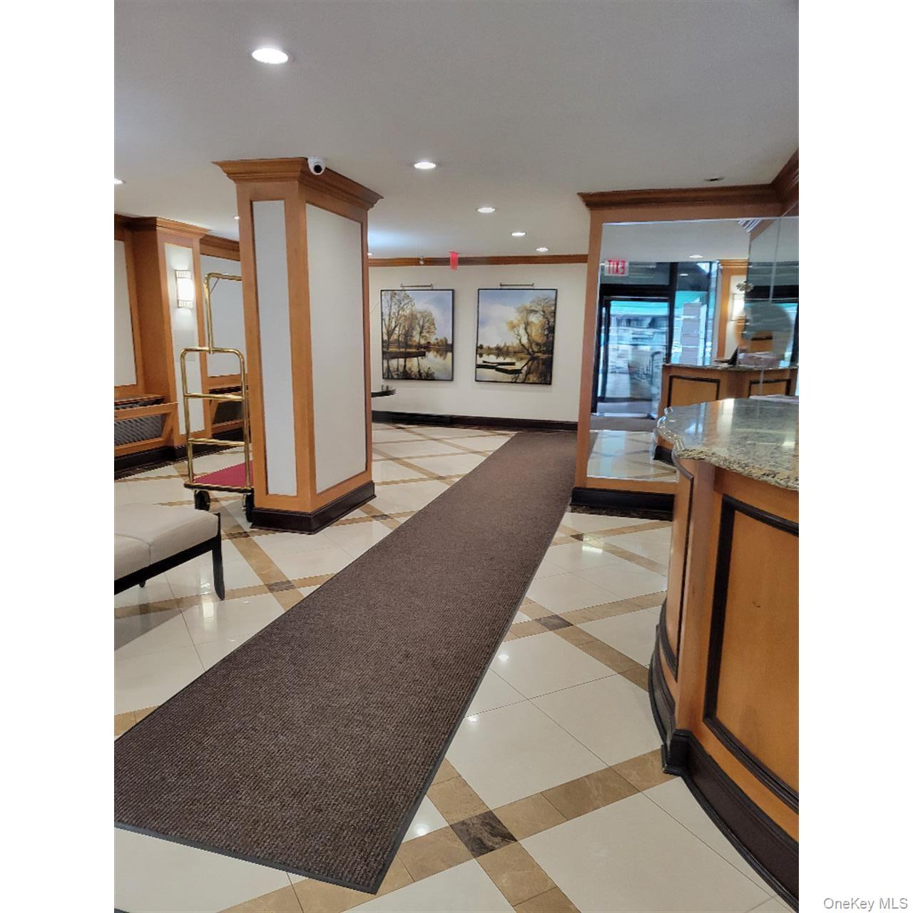 118-18 Union Turnpike, Unit 5J Queens, NY 11415 - Photo 4 of 24 a lobby with furniture and floor to ceiling window