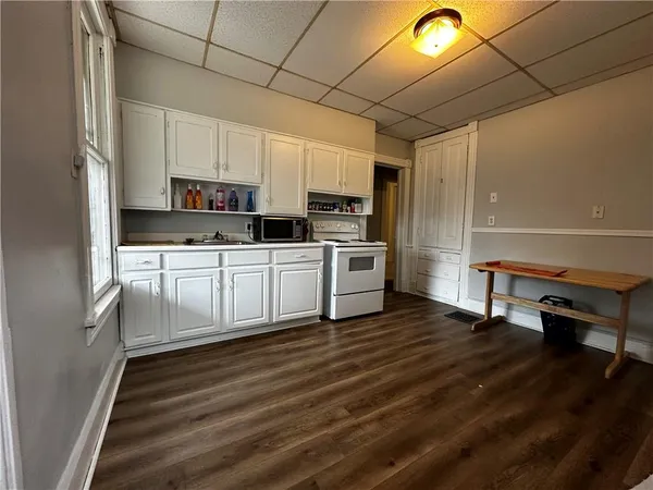 a kitchen with white cabinets and appliances