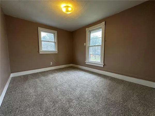 an empty room with windows and closet