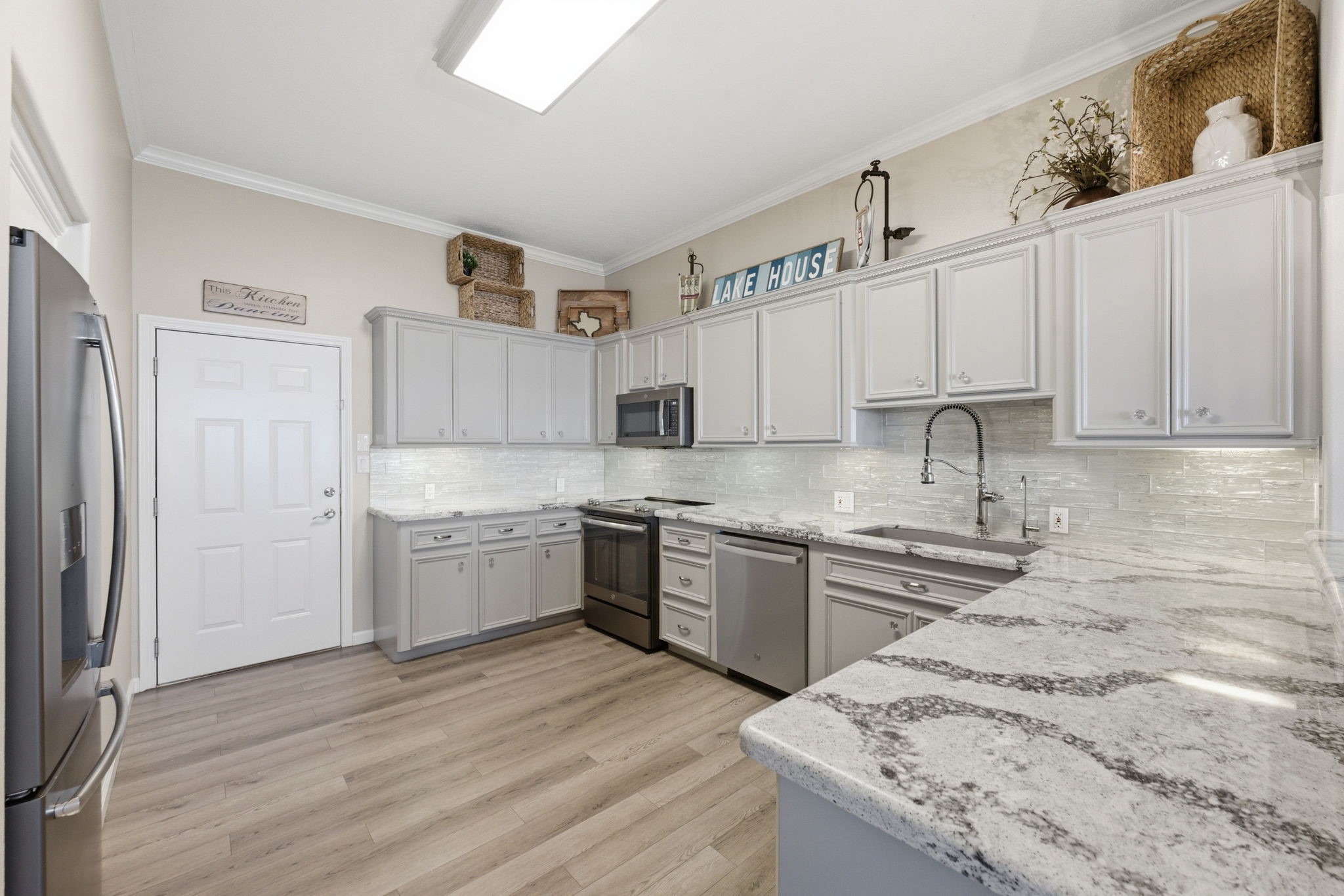2 Regency Point Conroe, TX 77356 - Photo 11 of 44 Spacious kitchen featuring Cambria quartz countertops, stainless steel appliances, designer tile backsplash, and abundant cabinetry for storage and prep space.