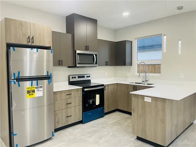 a kitchen with stainless steel appliances a refrigerator sink and stove
