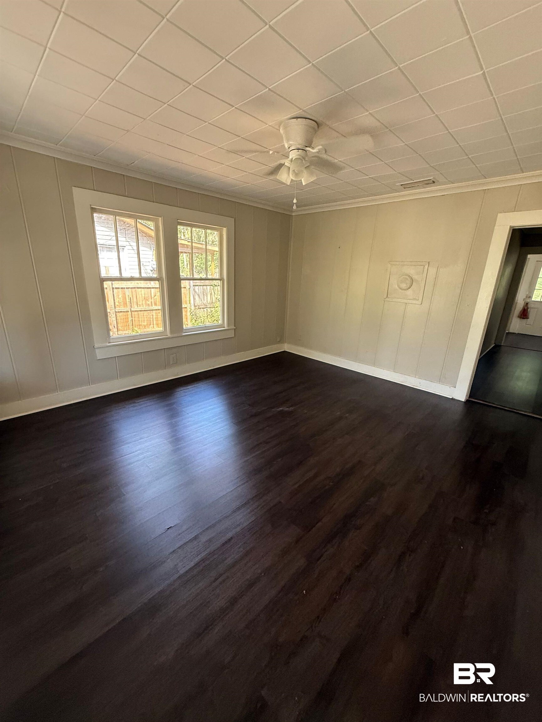 655 Mandrell Street Mobile, AL 36606 - Photo 4 of 12 Unfurnished bedroom with a decorative wall, dark wood finished floors, a ceiling fan, and a paneled ceiling