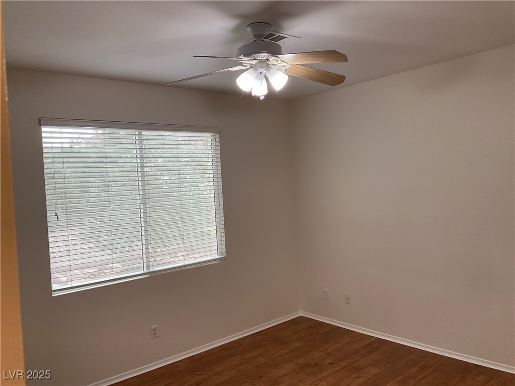 7620 Donald Nelson Avenue Las Vegas, NV 89131 - Photo 15 of 34 Unfurnished room with dark wood-style floors, ceiling fan, and baseboards