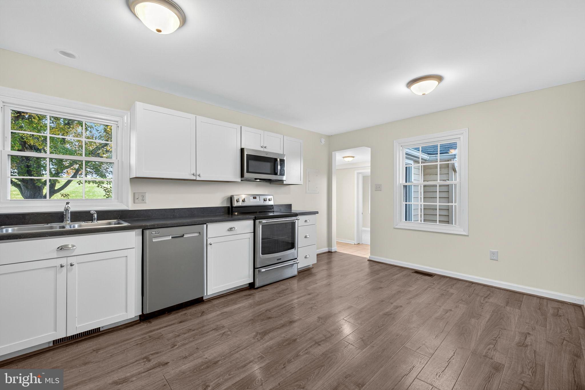 33018 Sunken Lane Upperville, VA 20184 - Photo 9 of 31 a kitchen with granite countertop a stove a sink and a microwave