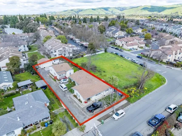 an aerial view of a pool a yard and mountain view in back