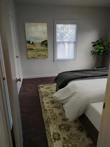 a bed sitting in a bedroom next to a window