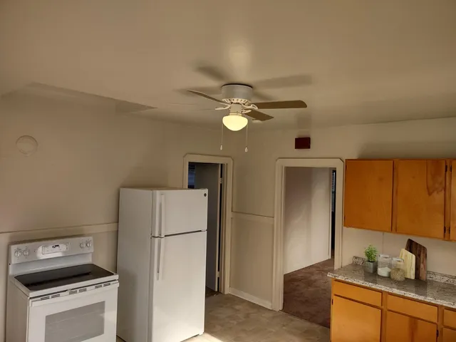 a kitchen with a refrigerator and a stove top oven