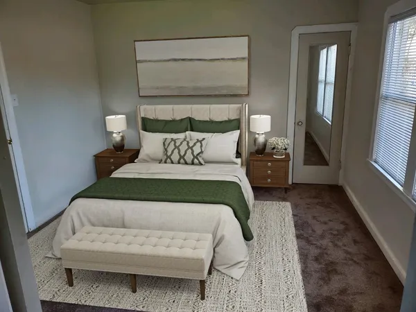 a bedroom with a bed a mirror and lamp