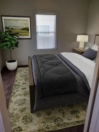 a bedroom with a bed and a potted plant