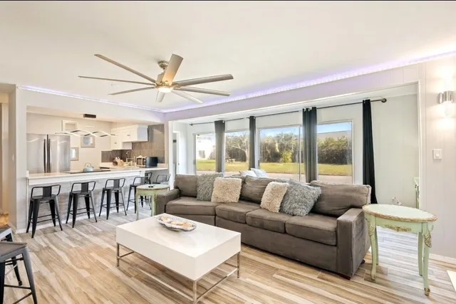 a living room with furniture a table and a large window