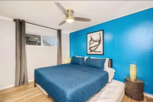 a bedroom with a bed and a lamp with the wooden floor