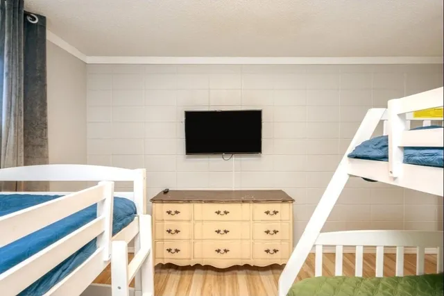 a living room with a flat screen tv on the wall and dresser