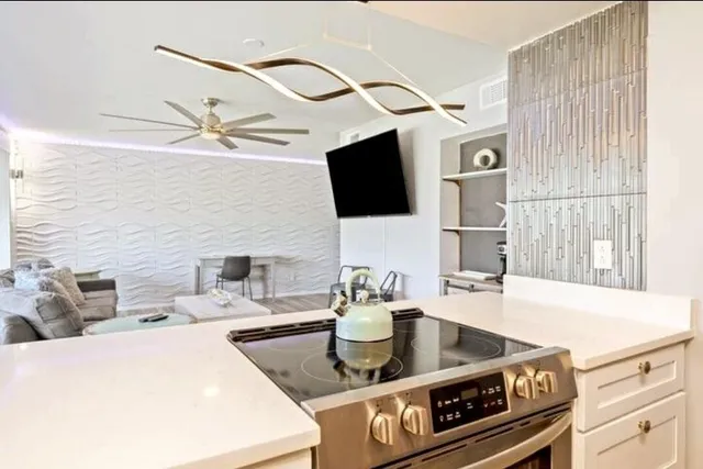 a kitchen with stainless steel appliances granite countertop a sink a stove and a microwave