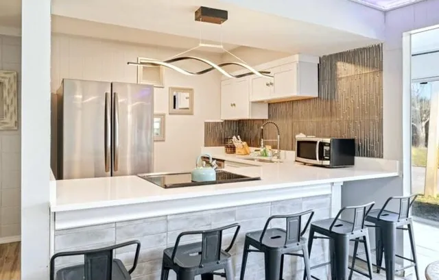 a kitchen with stainless steel appliances a table chairs and a refrigerator