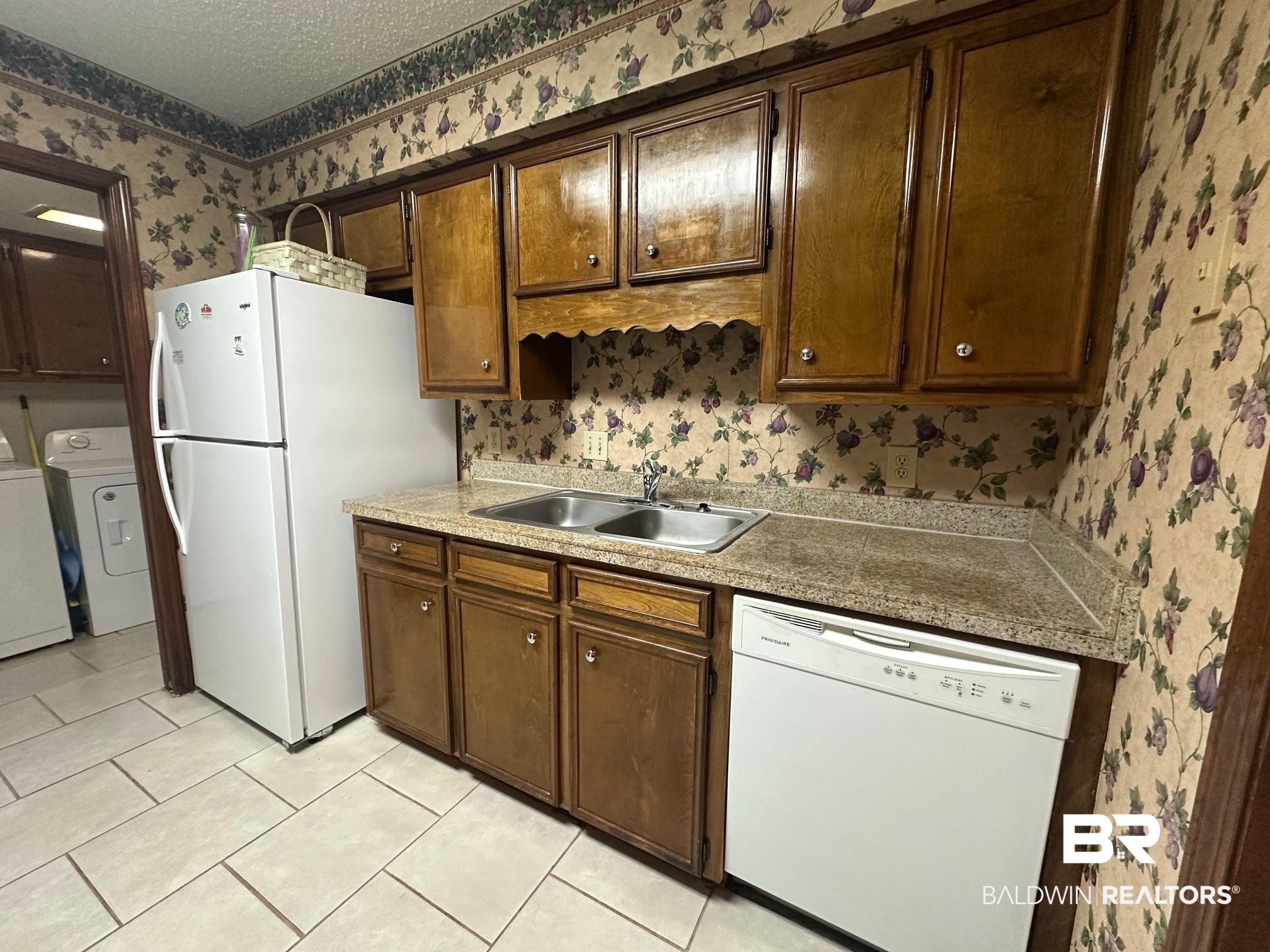 6533 Cedar Bend Court, Unit A Mobile, AL 36608 - Photo 9 of 16 Kitchen with wallpapered walls, white appliances, a textured ceiling, light countertops, and light tile patterned flooring