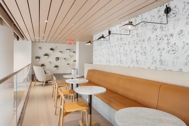 a view of a hallway with chairs and table in a room