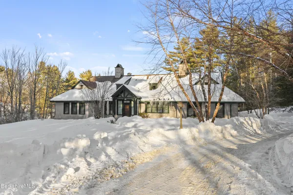 a front view of a house with a yard covered in snow