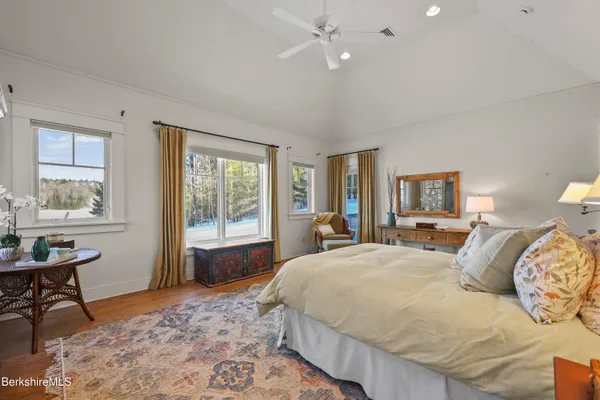 a spacious bedroom with a bed and a chair