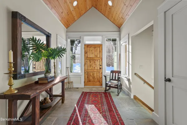 a living room with furniture a fireplace and a dining table with wooden floor