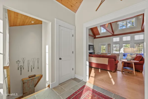 a living room with furniture a ceiling fan a rug and a large window