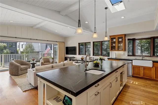 a kitchen with granite countertop a sink a counter top space and living room view
