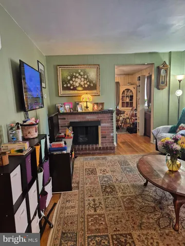 a living room with furniture a flat screen tv and paintings on the wall
